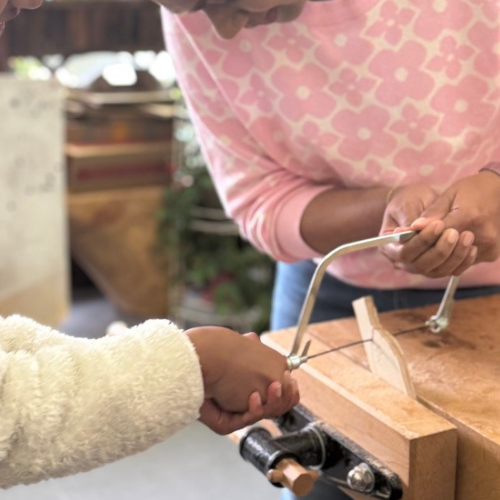 Participant carving wood during the Dog Lamp Workshop.