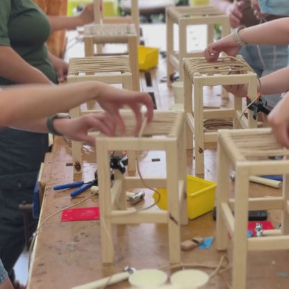 Participants weaving Danish cord stools in a workshop.