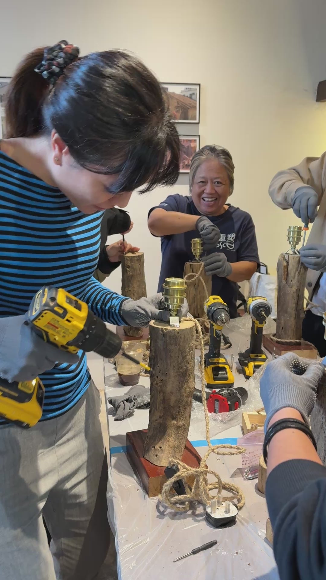 A participant using a drill for their driftwood lamp